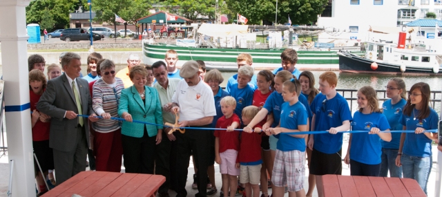 Mayor Tony Fratto, Canal Corps Director Brian Stratton, Senator Pattie Richie and the Bridgehouse Brats cutting the ribbon to open a new pavilion on the Phoenix waterfront (photo: Tom Larsen)